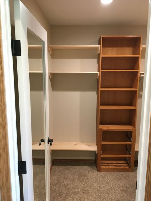 Walk-in closet with built-in shelving tower, mirror and bench seating