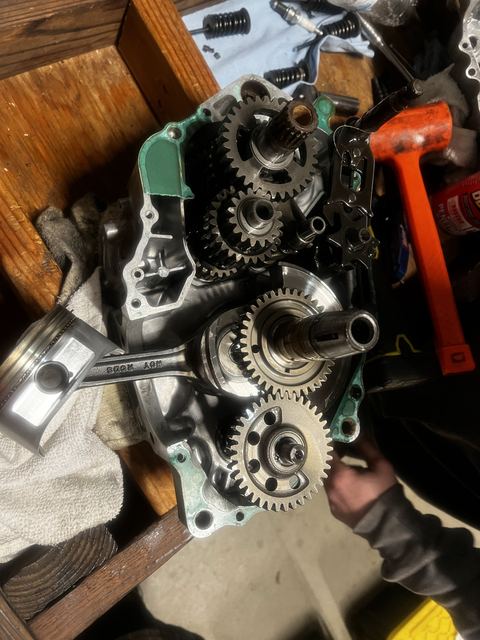 Open engine cases showing transmission gears and a removed piston