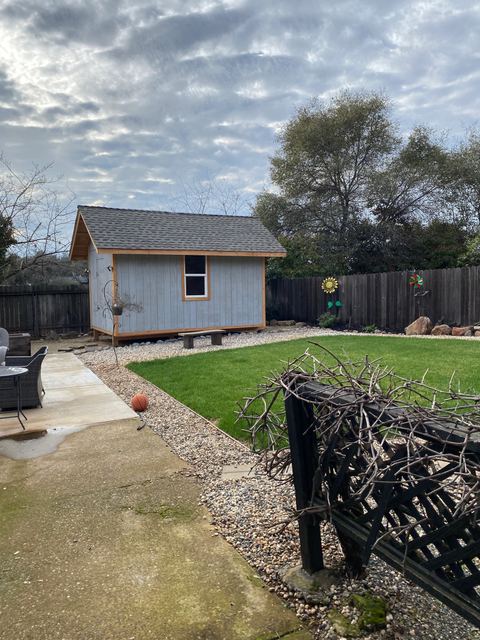 Completed backyard shed with surrounding gravel landscaping and lawn