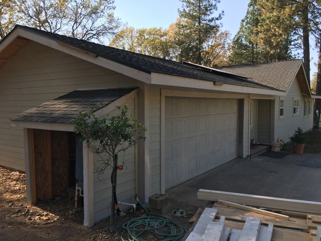 Garage exterior with new siding and roof tied into the main house