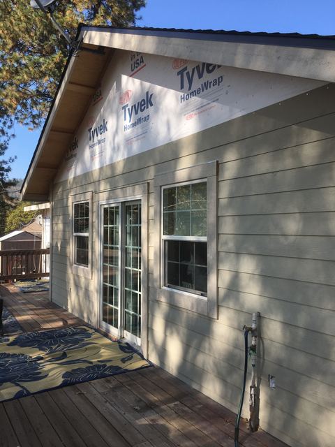 House exterior mid-install with house wrap and new siding partially installed